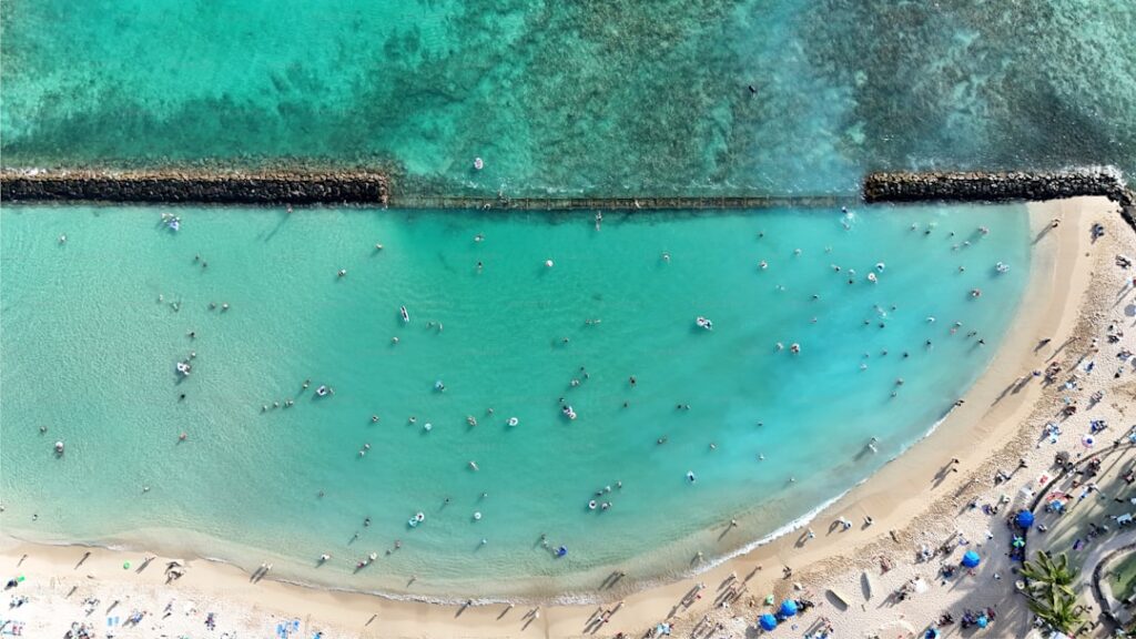 Top aerial panoramic view of beachguests and surfers waiting for some big waves on Waikiki Beach on a sunny day on O'ahu, Hawaii - USA. — Four Seasons Wailea Launches Premium Club Floor Experience | Maui Tom's News