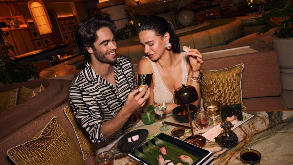 March Flooding Creates Federal Aid Centers Amid Record Wet Season - Maui Tom's Vacation Rental Cleaning & Maintenance Couple enjoying an upscale dinner, sharing sushi on a marble table.