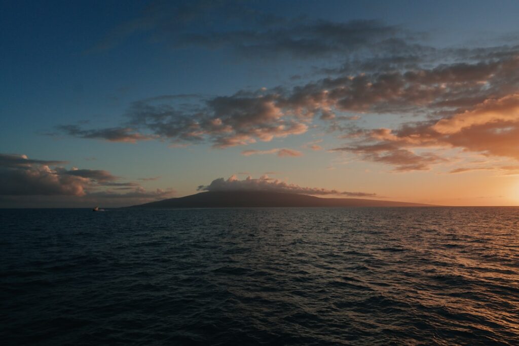The sun is setting over the ocean as seen from a boat — New DLNR Director Named as Dawn Chang Steps Down | Maui Tom's News