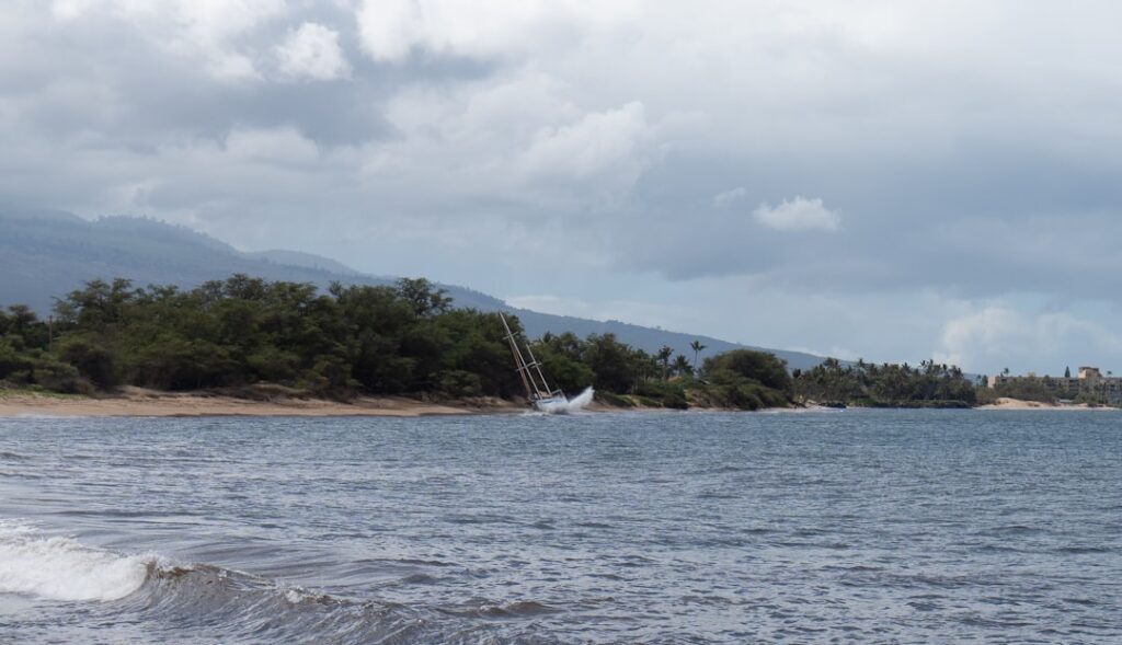 Maui County Eyes M Takeover of West Maui Private Water Systems - Maui Tom's Vacation Rental Cleaning & Maintenance A shipwrecked sailboat along the Maui coastline, a dramatic scene framed by the island’s lush greenery and ocean waves. — Maui County Eyes $6M Takeover of West Maui Private Water Systems | Maui Tom's News